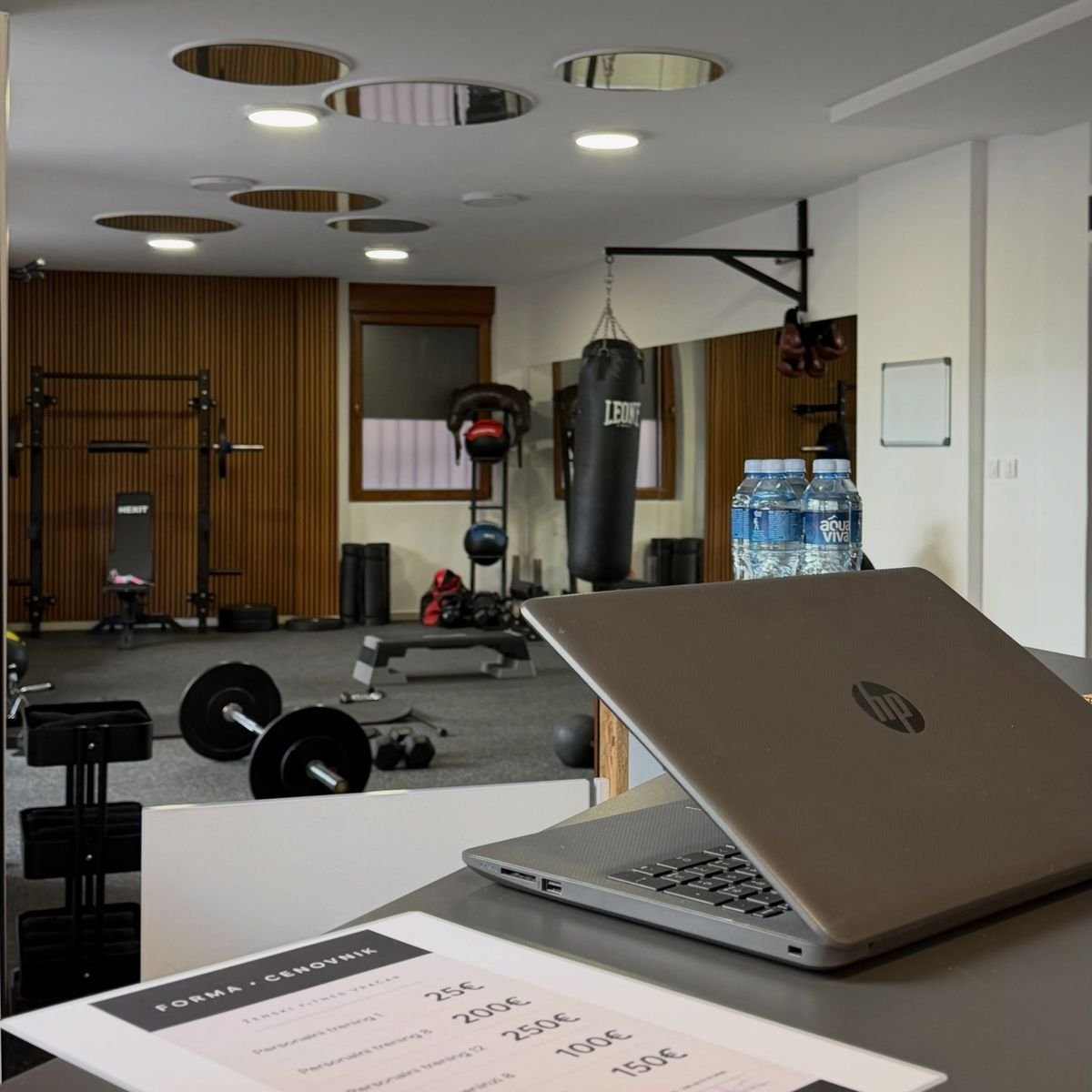 Recepcija sa cenovnikom, a iza nje sala sa rackom i vrećom za boks